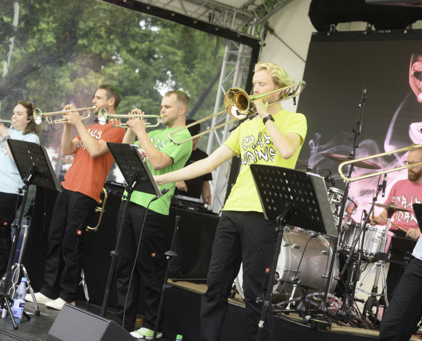 Auf dem Sommerfest spielt eine Brass-Band spielt live auf einer Rundbogen-Bühne