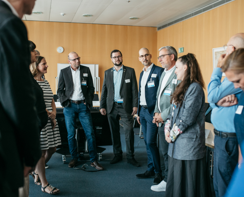 Gruppendiskussion zur effektiveren Integration von Geflüchteten in den Arbeitsmarkt in einem mit Holzvertäfelung versehenen Büroraum des BMWK